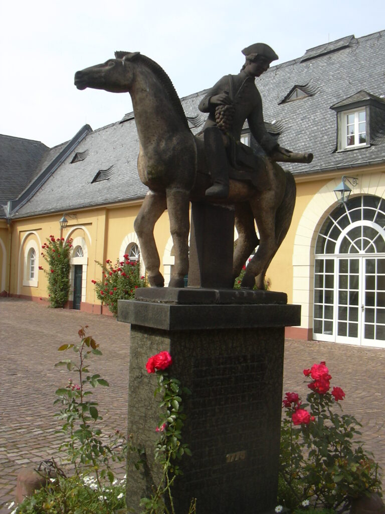Denkmal an den Spätlesereiter mit Weintrauben in der Hand auf Schloss Johannisberg.